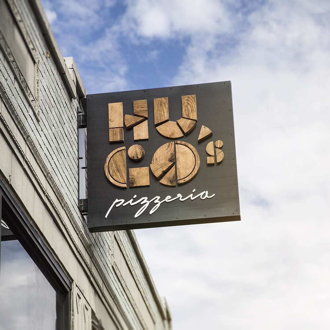 Outdoor signage of logo for Hugo's Pizzeria
